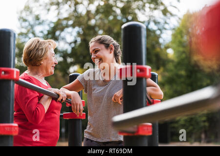 Nonna e nipote training su barre in un parco Foto Stock