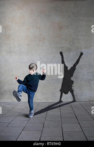 Germania, Duesseldorf, muovendo little boy e ombra di Duesseldorf's cartwheeler in background Foto Stock