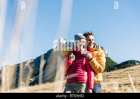 Austria, Tirolo, felice coppia abbracciando su una escursione in montagna Foto Stock