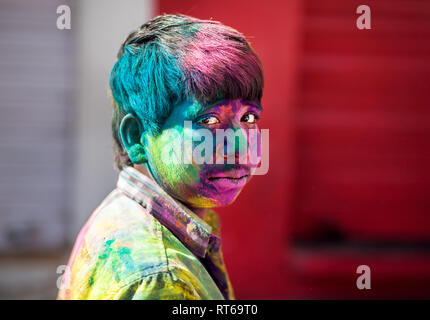 Udaipur, India - 6 Marzo 2015: Ritratto di ragazzo indiano con faccia dipinta celebrando il coloratissimo festival di Holi sulla strada. Foto Stock