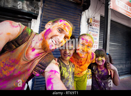 Udaipur, India - 6 Marzo 2015: Selfie foto di bambini Indiani e coppia estera con faccia dipinta celebrando il coloratissimo festival di Holi sul Foto Stock