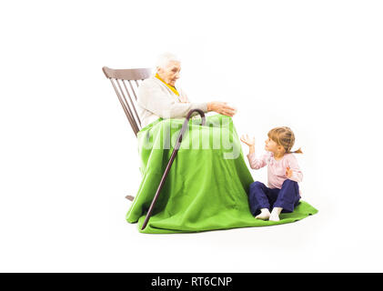 Il vecchio donna seduta sulla sedia a dondolo con i suoi nipoti Foto Stock