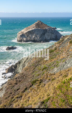 Onde infrangersi contro un grande cappello a forma di pila di mare isolato nell'Oceano Pacifico, appena fuori il Big Sur litorale in California. Foto Stock