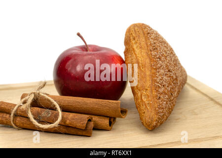 In casa di pasta sfoglia fatturati Apple, Apple e bastoncini di cannella su un tagliere di legno isolato su sfondo bianco Foto Stock