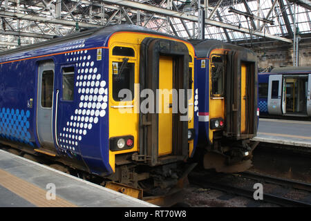 Due della classe 156 super sprinter diesel unità multiple in diverse livree Scotrail aspettando a piattaforme nella stazione centrale di Glasgow 25 Feb 2019. Foto Stock