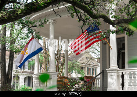 Garden District di New Orleans, vista tipica di un portico con colonne e bandiere che sventolano nella sistemazione di giardino residenziale quartiere di New Orleans, STATI UNITI D'AMERICA Foto Stock