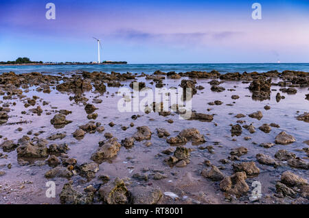 Fonti di energia con le turbine eoliche in mare nel tramonto Foto Stock