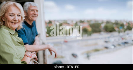 Sorridente coppia senior al balcone che guarda a vista Foto Stock