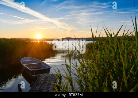 Germania, Meclemburgo-Pomerania, Ruegen, Sellin, vuoto barca a remi vicino molo al tramonto Foto Stock