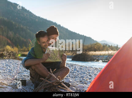 Coppia matura campeggio al Riverside, cerca sulla mappa Foto Stock