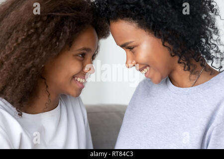 Nero la figlia e la madre guardando ogni altro e sorridente Foto Stock