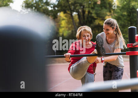 Nonna e nipote training su barre in un parco Foto Stock