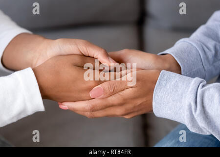 Nero a madre e figlia holding hands close up Foto Stock