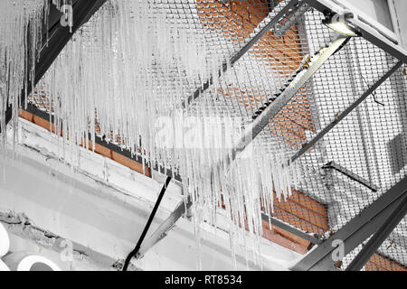 Icicle sul tetto del tubo,Edificio coperto con grandi ghiaccioli,ghiaccioli pendono dai roo Foto Stock