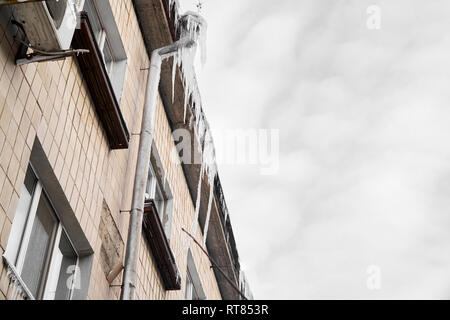 Icicle sul tetto del tubo,Edificio coperto con grandi ghiaccioli,ghiaccioli pendono dai roo Foto Stock