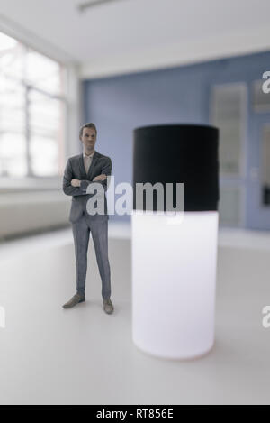 Imprenditore in miniatura statuetta in piedi accanto alla casa di smart device Foto Stock