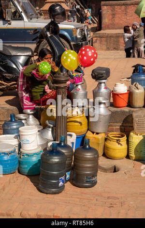 Il Nepal, Valle di Kathmandu, Bhaktapur, donna che soffia su palloncini a pubblico acqua di rubinetto di alimentazione Foto Stock