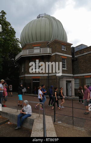 I turisti a piedi passato il grande storico edificio equatoriale con un telescopio cupola all'Osservatorio Reale di Greenwich a Londra, Regno Unito. Foto Stock