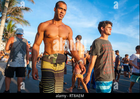 RIO DE JANEIRO - 28 febbraio 2017: Giovani carnivalgoers a piedi lungo la spiaggia di Ipanema che mostra in un pomeriggio street party. Foto Stock