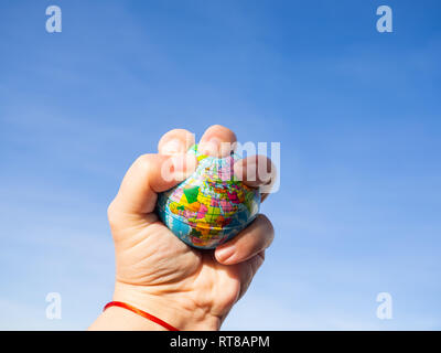 Una persona di distruggere con una mano il globo terrestre o il pianeta terra. Concetto di ecologia Foto Stock