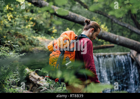 Giovane escursionista con zaino in foresta Foto Stock