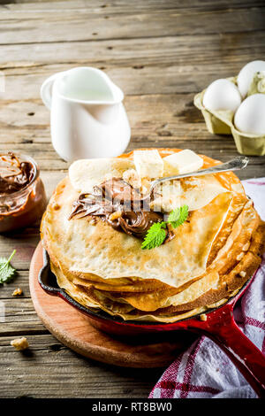Crepes fatte in casa con salsa di cioccolato, russo e ucraino frittelle sottili bliny, in legno rustico sfondo spazio di copia Foto Stock