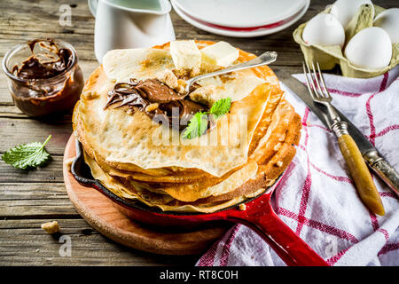 Crepes fatte in casa con salsa di cioccolato, russo e ucraino frittelle sottili bliny, in legno rustico sfondo spazio di copia Foto Stock