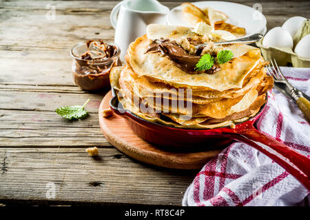 Crepes fatte in casa con salsa di cioccolato, russo e ucraino frittelle sottili bliny, in legno rustico sfondo spazio di copia Foto Stock