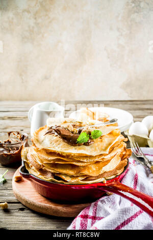 Crepes fatte in casa con salsa di cioccolato, russo e ucraino frittelle sottili bliny, in legno rustico sfondo spazio di copia Foto Stock