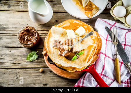 Crepes fatte in casa con salsa di cioccolato, russo e ucraino frittelle sottili bliny, in legno rustico sfondo spazio di copia Foto Stock