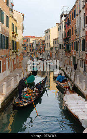 Venezia, Italia - 12 Gennaio 2019: un gondoliere porta alcuni turisti lungo un tranquillo canale nel sestiere di Dorsoduro Foto Stock