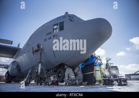 Avieri dal 179th Airlift Wing, Mansfield, Ohio, lavorando nel vento sottozero brividi sul carrello di atterraggio di un C-130H Hercules, 25 gennaio, 2019. Il C-130 è da 136Airlift Wing, Texas Air National Guard, stazionati alla Naval Air Station giunto di base riserva di Fort Worth, Fort Worth, Texas. Foto Stock