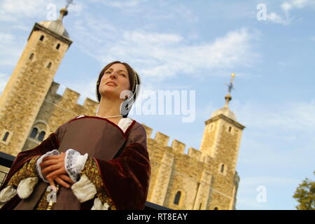 Una giovane e bella donna vestita come Anne Boleyn si siede da una finestra alla Torre di Londra e guarda pensieroso. Foto Stock