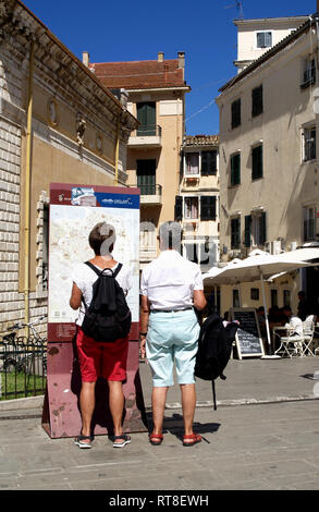 Turista giovane consultare strret mappa in vicoli e modi di vicolo della vecchia città di Corfù, Corfu, Grecia Foto Stock