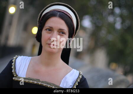 Una giovane e bella donna in autentico abito Tudor guarda nella telecamera e sorrisi- Foto Stock