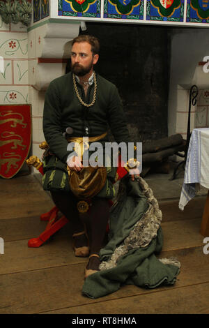 Un ben vestito Tudor uomo di fronte a un grande caminetto presso la Torre di Londra Foto Stock