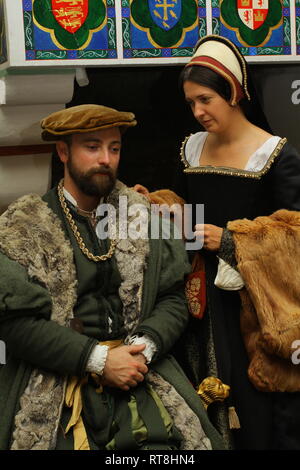 Un ben vestito Tudor giovane chat nella parte anteriore di un grande caminetto presso la Torre di Londra Foto Stock