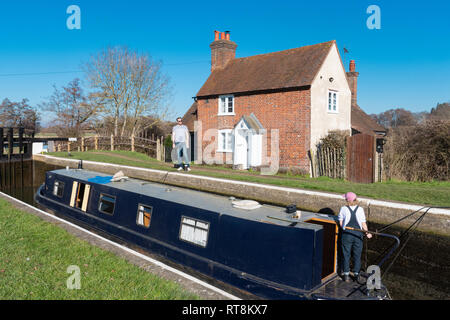 Narrowboat o Inclus passando attraverso il blocco Triggs accanto a bloccare i detentori cottage sulla navigazione Wey vicino a inviare nel Surrey, Regno Unito Foto Stock