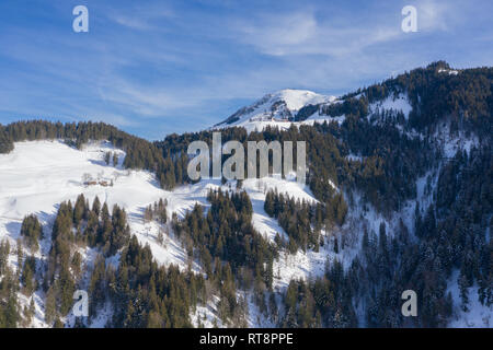 Vista aerea di cottage sulla cima di una montagna delle Alpi durante l'inverno. Foto Stock