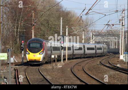 Classe 390 Pendolino elettrico unità multiple in treno in Vergine Costa Ovest fluente livrea di seta lasciando Lancaster stazione ferroviaria, WCML, 25 febbraio 2019. Foto Stock