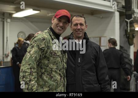 Grandi laghi, Ill. (GEN. 25, 2019) Capo di operazioni navali (CNO) Adm. John Richardson in posa per una foto con Aviation Ordnanceman 1a classe Matteo Timour all'interno di USS Marlinespike ad assumere il comando di formazione (RTC). Il CNO è in visita a RTC, la marina è solo boot camp, per osservare i cambiamenti nella formazione che sono il miglioramento delle abilità di combattimento e di tenacità in marina del più recente dei marinai. Più di 30.000 reclute graduate annualmente dalla marina è solo di boot camp. Foto Stock