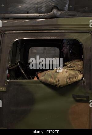 Un soldato dell'esercito assegnato al 314Intelligence militare comando Readiness prepara per off-load di un Humvee da una C-5M Super galassia a Kalaeloa aeroporto, HI, 25 gennaio 2019, durante l'esercizio Patriot Palm. Esercizio Patriot Palm è un comune servizio di esercizio coordinato dalla Air Force Riserva, progettate per integrare i soccorritori da federale, lo stato e gli enti locali e i militari fornendo una rapida formazione di risposta in caso di emergenza regionale o calamità naturali. Foto Stock