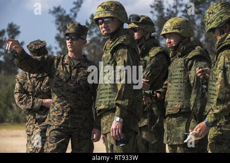 Col. Robert "Bams" Brodie, 31 Marine Expeditionary Unit comandante, parla con i membri del Giappone terra Forza di Autodifesa osservando la simulazione di una barca a raid Kin Blue Beach, Okinawa, in Giappone, 25 gennaio, 2019. Gli scambi offrono opportunità per la III Marine forza expeditionary Marines e marinai e Giappone Forza di Autodifesa personale, per osservare la formazione dei loro omologhi al fine di aumentare la comprensione reciproca e l'interoperabilità. Il trentunesimo MEU, il Marine Corps' solo in modo continuo distribuita MEU collaborando con la Vespa Anfibia Gruppo pronto, fornisce una flessibile Foto Stock