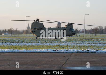 Un U.S. Esercito membro di equipaggio esce un CH-47 elicottero Chinook con il primo combattimento Brigata Aerea, 1a divisione di fanteria, messa in scena Wingene Air Base, Belgio, Gennaio 30, 2019. Wingene Air Base è servita come un intermedio area di sosta prima della 1a combattere la Brigata Aerea distribuisce in Germania, Polonia, Lettonia e Romania per nove mesi al treno con i partner della NATO a sostegno della Atlantic risolvere. Foto Stock