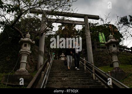 I residenti di Okinawa a piedi verso il basso dei passaggi durante la Nago City cinquantesimo annuale di Cherry Blossom Festival a Nago Central Park, a Okinawa, Giappone, Gennaio 27, 2019. La città di Nago ospita ogni anno il Cherry Blossom Festival che attrae più di 270.000 persone ogni anno. Intrattenimento per il festival inclusi giochi di carnevale, i fornitori di prodotti alimentari, composizioni floreali, karaoke, concorsi e una varietà di spettacoli culturali. Foto Stock