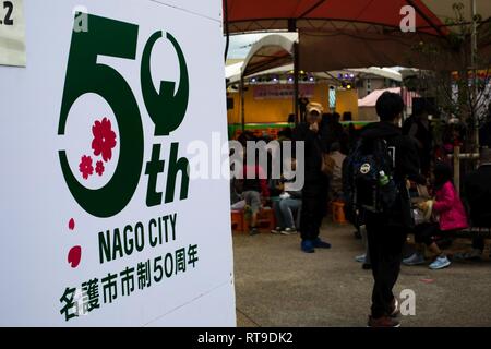 I residenti di Okinawa e status delle forze accordo personale celebrare la città di Nago cinquantesimo annuale di Cherry Blossom Festival a Nago Central Park, a Okinawa, Giappone, Gennaio 27, 2019. La città di Nago ospita ogni anno il Cherry Blossom Festival che attrae più di 270.000 persone ogni anno. Intrattenimento per il festival inclusi giochi di carnevale, i fornitori di prodotti alimentari, composizioni floreali, karaoke, concorsi e una varietà di spettacoli culturali. Foto Stock