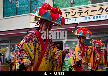 I residenti di Okinawa eseguire danze culturali durante la Nago City cinquantesimo annuale di Cherry Blossom Festival a Nago Central Park, a Okinawa, Giappone, Gennaio 27, 2019. La città di Nago ospita ogni anno il Cherry Blossom Festival che attrae più di 270.000 persone ogni anno. Intrattenimento per il festival inclusi giochi di carnevale, i fornitori di prodotti alimentari, composizioni floreali, karaoke, concorsi e una varietà di spettacoli culturali. Foto Stock