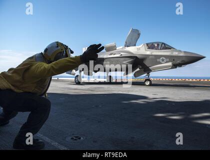 Mare delle Filippine (Jan 28, 2019) -- Aviazione di Boatswain Mate (movimentazione) terza classe Rulloda Noel, da Chicago, segnali il lancio di un F-35B Lightning II aeromobili appartenenti alle Marine Fighter Attack Squadron 121 dal ponte di volo dell'assalto anfibio nave USS Wasp (LHD 1). Wasp, ammiraglia di Vespa Anfibia Gruppo pronto, con avviato 31 Marine Expeditionary Unit, è operativo nell'Indo-Pacifico regione per migliorare l'interoperabilità con i partner e servire come una pronta risposta in vigore per qualsiasi tipo di emergenza. Foto Stock