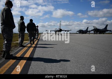 Avieri dal centottantesimo Fighter Wing, Ohio Air National Guard, guardare come un F-16 Fighting Falcon i taxi per la pista prima di decollare a Patrick Air Force Base in Florida il 7 gennaio 28, 2019. Come parte della Patrick AFB di implementazione, il 180FW sarà condotta dissimile Air Combat Training, Basic Fighter manovre, aria difensivo contro le tattiche e tattiche di missioni di intercettazione a fianco F-15 Aquile assegnato alla 104th Fighter Wing, Barnes Air National Guard Base, Massachusetts. Foto Stock