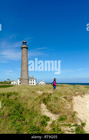 Danimarca, nello Jutland, Skagen, Grenen, donna in piedi di dune grigio a faro Foto Stock